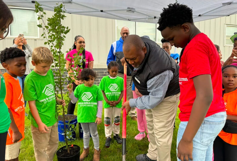 An adult and kids plant a tree with in partnership with the Boys & Girls Club of Fort Wayne.