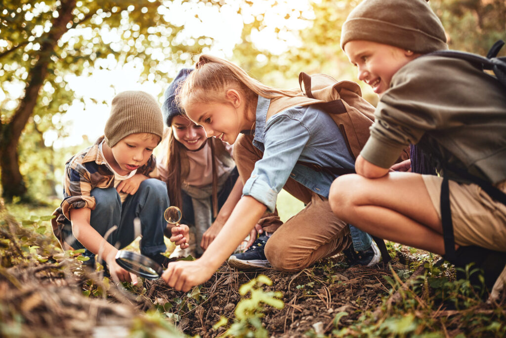 Kids examine leaves outside in the AEP Nature Explore Classroom in Fort Wayne, Ind.
